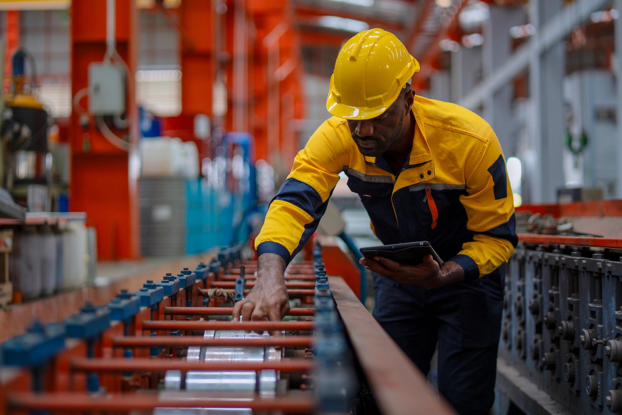 Industrial technician reviewing equipment in a factory environment